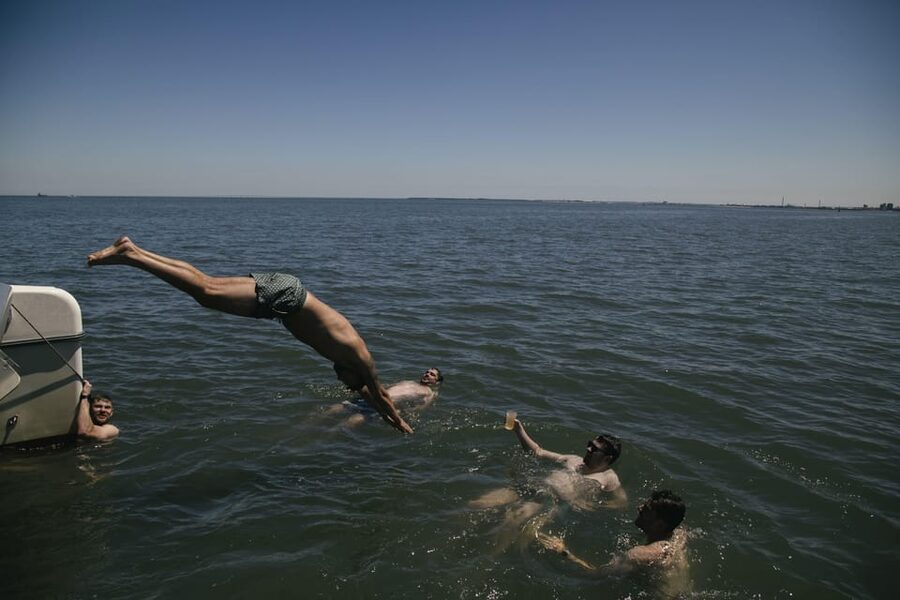 Lisbon: Catamaran Boat Party with Music, Open Bar & Dives - Water time without the fuss: using the boat ladder to cool off